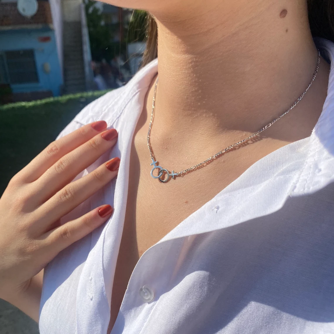Collier lesbien argenté sur chemise blanche