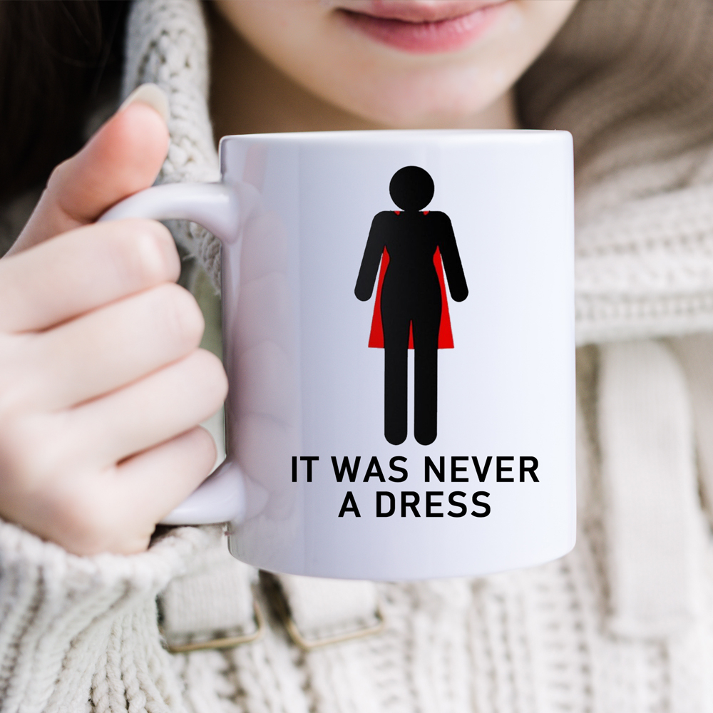 Mug féministe blanc It Was Never a Dress tenu par son anse