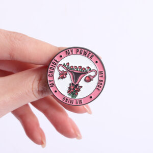 Pin utérus fleuri My Body My Choice tenu dans la main