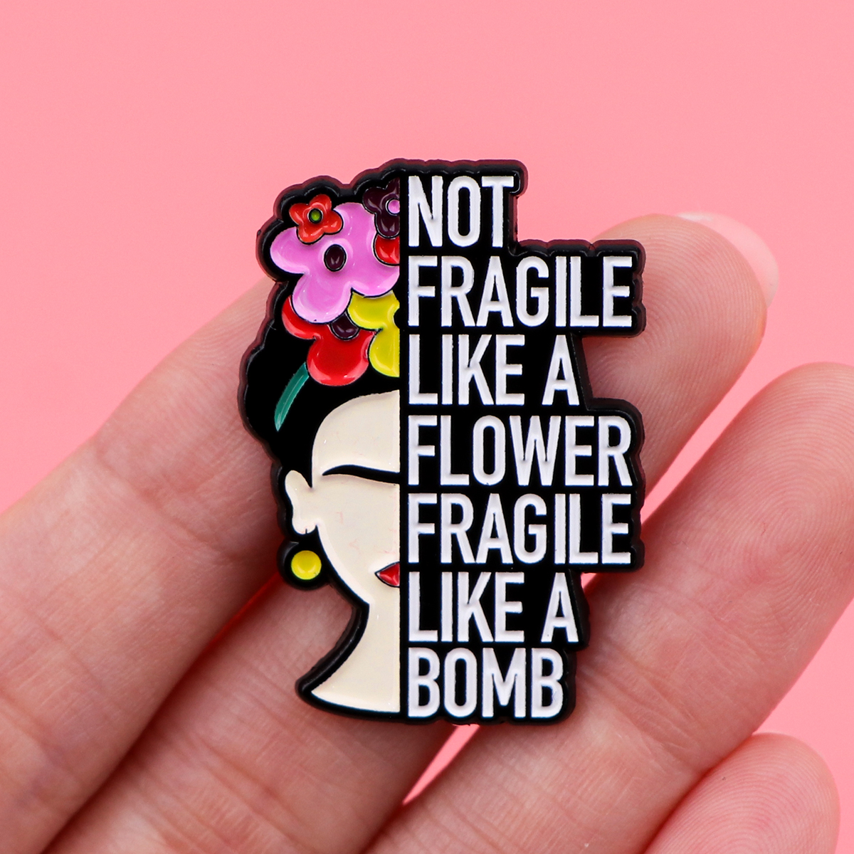 Pin Frida Fragile Like a Bomb tenu dans une main